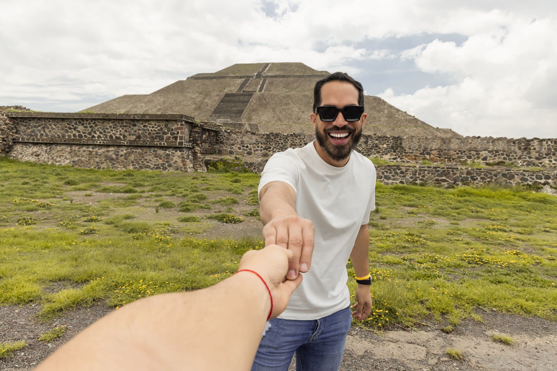 tempel-anlage-gay-couple-holding-teotihuacan-pyramid-gay-reise-mexiko-urlaub-wandern-lgbtqia+